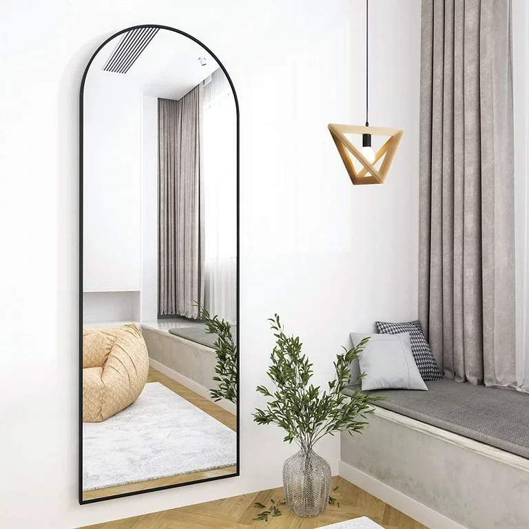 An arched floor mirror